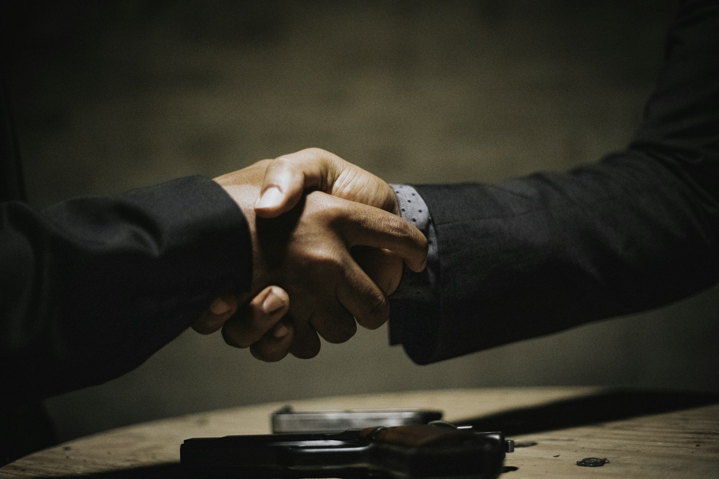 Two business people shaking hands over a table