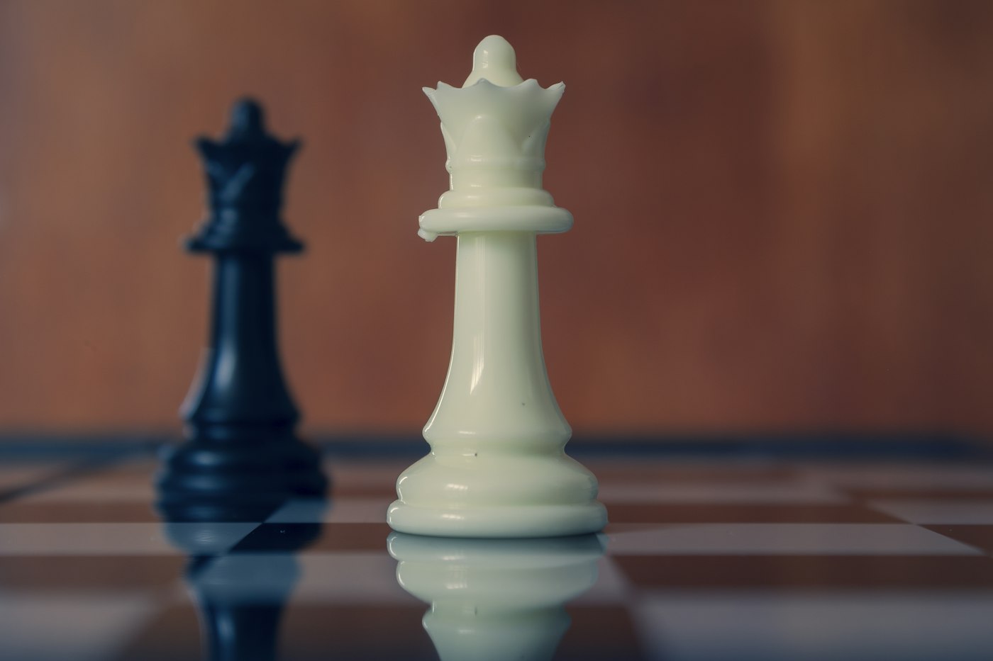 Black and white chess queens facing each other